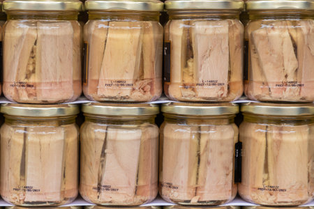 close up in horizontal view of several glass jars with preserved fillets of white tuna. food preservation conceptの写真素材
