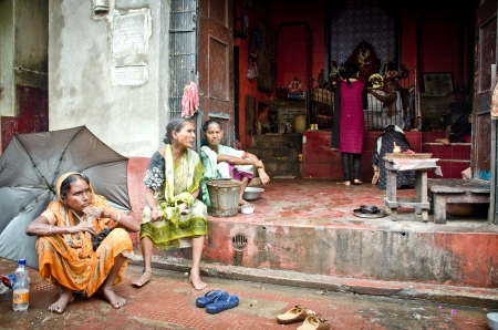 Kolkata, India -August 28,2012: three women begging for charity under the rain in front of a Kali temple. A woman without husband is often damned to live as a beggarのeditorial素材