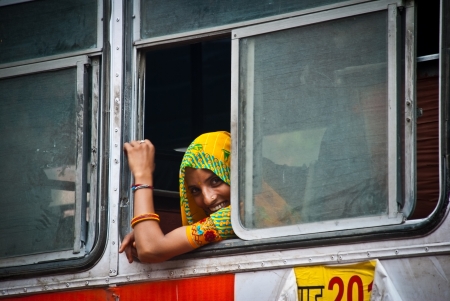 Jaipur, India, August 21, 2008: unidentified young woman smiles from the window on the bus from Jaipur to Udaipur. のeditorial素材