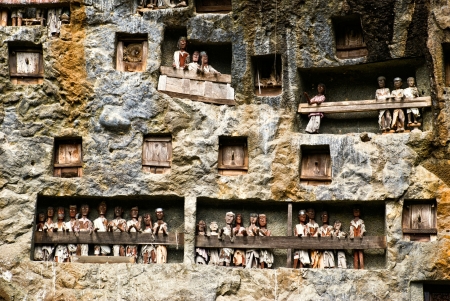 Traditional Tau tau, wooden statues representing dead men in a rock wall near Lemo, Sulawesi, Indonesiaの写真素材