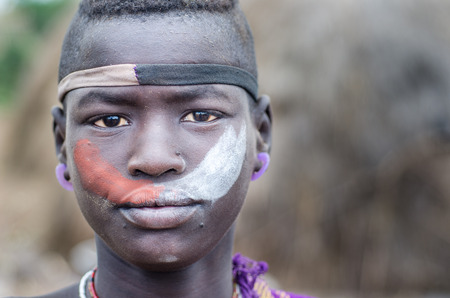 JINKA, ETHIOPIA - AUGUST 10  portrait of unidentified Mursi boy on August 10 2014  Mursi tribes usually paint their bodies and faces with colored pigmentのeditorial素材