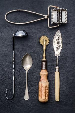 Collection of retro kitchen tools on a blak stone. dark moodの写真素材