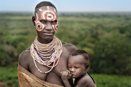 Kolcho, Ethiopia - August 12: unidentified woman from Karo tribe with her children in Kolcho, Ethiopia, 12 august 2014. Karo women paint their body with natural pigmentsのeditorial素材
