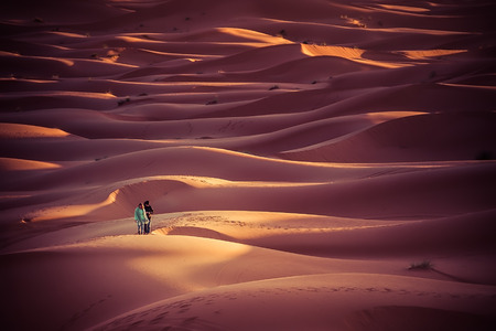 Merzouga Morocco  27 March 2015: unidentified people walk in the dunes of the Sahara desert at sunrise. Spend a night in the desert and look at the sunrise is one of the main actration of Moroccoのeditorial素材