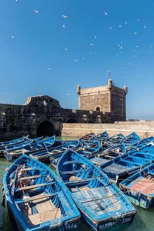 Blue boats in the harbour of Essaouira and the tower of the fortification wallsのeditorial素材