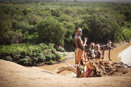 KOLCHO, ETHIOPIA - 18 AUGUST 2015: unidentified woman painting the faces of her children with natural pigment. The Karo tribe is endangered because governament is taking away their land.のeditorial素材