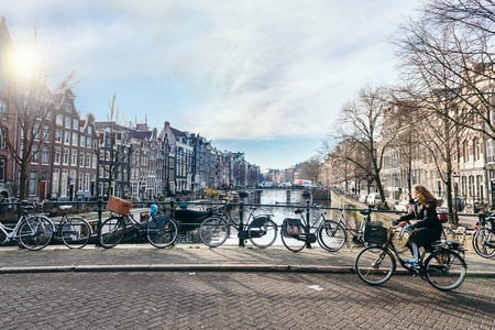 AMSTERDAM, THE NETHERLANDS - JANUARY 20, 2017: Bycicles parking on a bridge in one of the canals of Amsterdam. Bicycles are one of the main means of transport in the city, The Netherlandsのeditorial素材