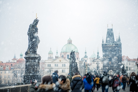 Tourists visiting Charles Bridge (KarlÃÂ¹v Most) in Prague under the snow.の写真素材