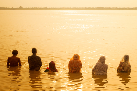 VARANASI, INDIA - AUGUST 27, 2008: unidentified people make the morning rituals (puja) in the water of the river Gangesのeditorial素材