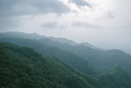 Cloudy and foggy landscape of mountains covered of forests, Indiaの写真素材