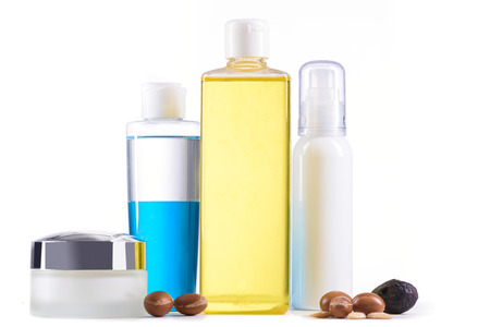 White cosmetic products with argan fruits for skin care and hair on a white background. Space for labels and graphicsの写真素材
