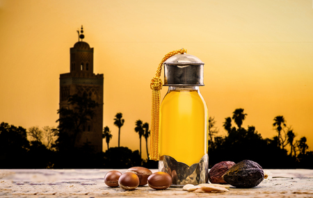 Bottle of argan oil and fruits for skin care with moroccan landscape on the backgroundの写真素材