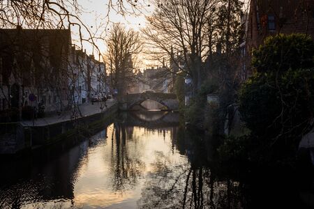 water canals of Bruges, Belgium, in a winter sunny day at sunsetの写真素材