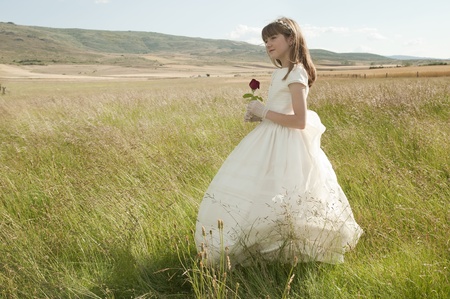 girl wearing first communion dress in the meadowの写真素材