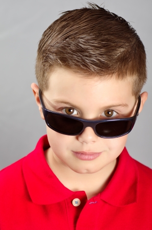 portrait of a boy with sunglasses and red sweaterの写真素材