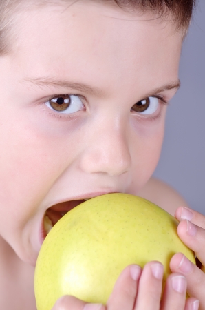 portrait photograph of a child with an apple in his handsの写真素材