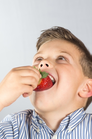 
portrait photograph of a child eating strawberriesの写真素材