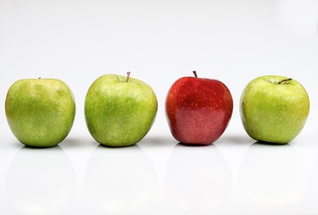 photograph of three green and a red apple on white backgroundの写真素材