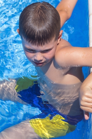 photograph of a child relaxing by the poolの写真素材