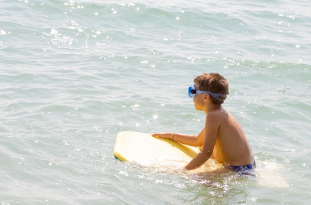 photograph of a child taking his first surfing lessons on the beachの写真素材
