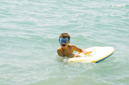 photograph of a child taking his first surfing lessons on the beachの写真素材