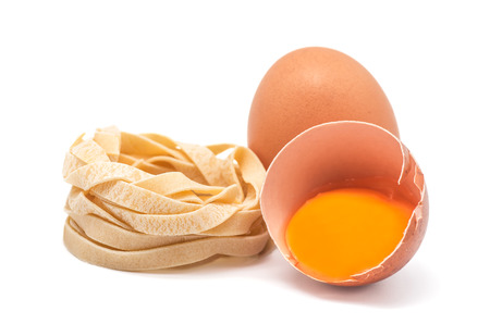 photograph of an egg and a half with several nests of pastaの写真素材