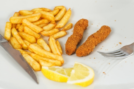 savoring a delicious plate of chicken sticks with friesの写真素材