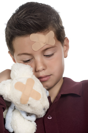 photographic portrait of a boy with sun stuffed bunny both injuredの写真素材