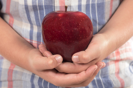 studio photography of hands holding a beautiful red appleの写真素材