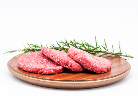 Photography Studio Three raw burgers with a sprig of rosemary on a white backgroundの写真素材
