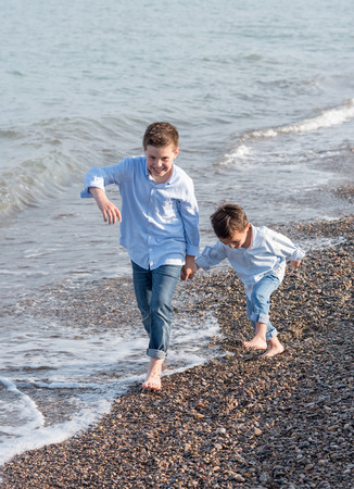 Sign up portrait of two children on beachの写真素材