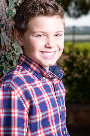 Sign up portrait of a young boy of ten outdoorの写真素材