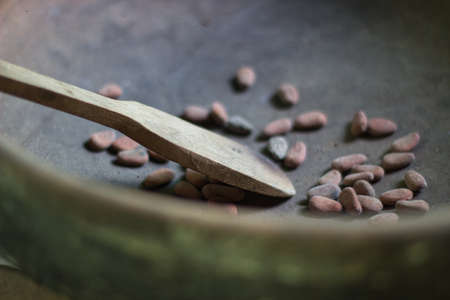 Wooden spoon in a bowl with pebbles, selective focus