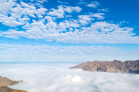 Clouds between the mountains in a blue skyの写真素材