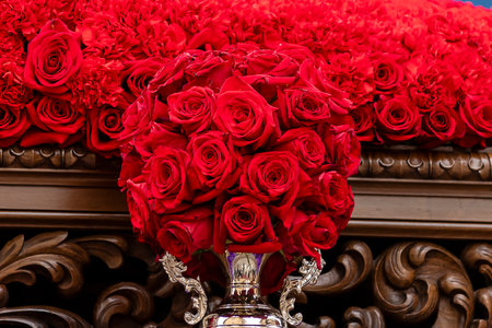 A stunning bouquet of red roses in a silver vase stands out at a floral event, enhancing the vibrant atmosphere.の写真素材