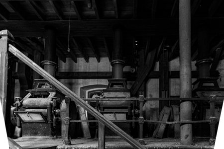 Old milling machines are lined up in a dimly lit workshop, highlighting historical craftsmanship and industry.の写真素材