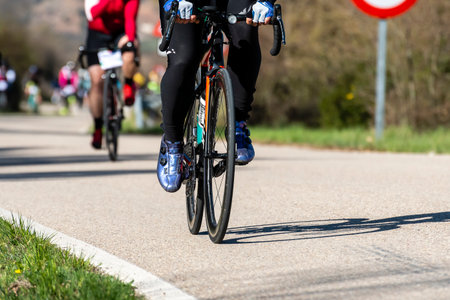 Participants are racing on a smooth road, showcasing their skills under a clear blue sky in springtime.の写真素材
