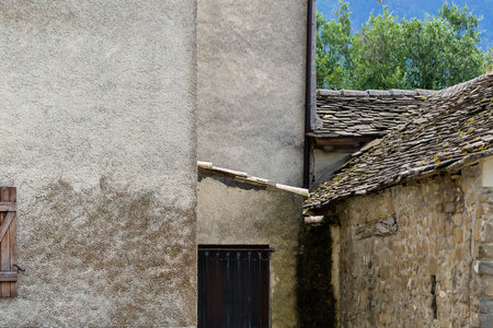 Old stone buildings under a clear blue sky in a rural village surrounded by mountainsの写真素材
