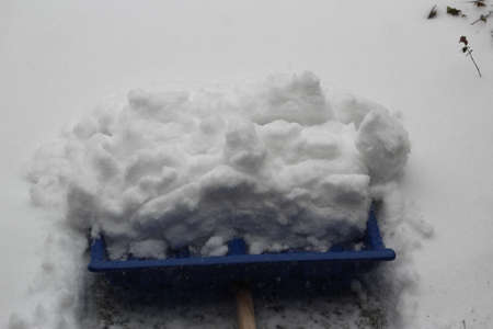 Close up of a blue snow shovel with pushed snowの写真素材