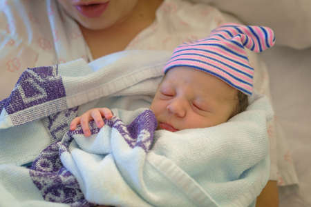 Newborn baby in the arms of his motherの写真素材