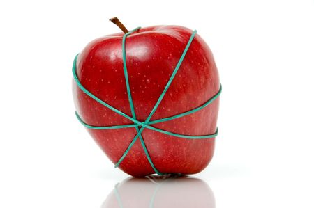 apple tied in rubber bands over a white backgroundの写真素材