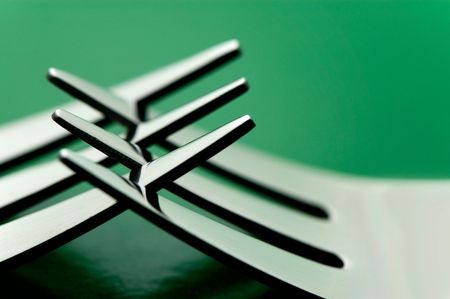 some silverware forks against a green backgroundの写真素材