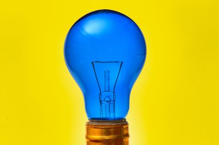 blue light bulb isolated over yellow backgroundの写真素材