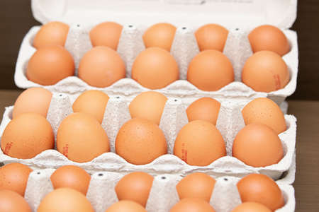 Brown and organic chicken egg tray on the table.