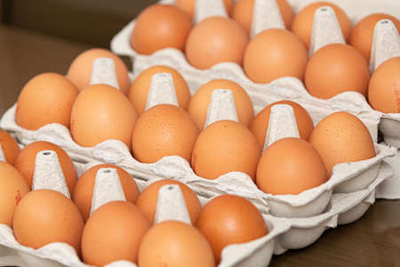 Brown and organic chicken egg tray on the table.