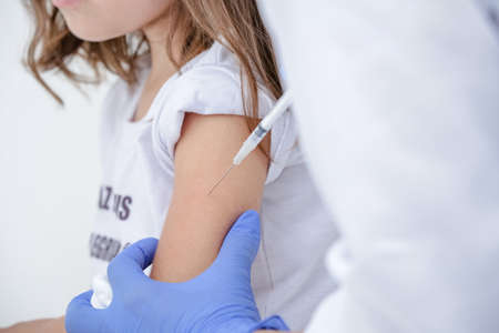 Vaccine for child medic with blue glove holding syringe with needle.の写真素材
