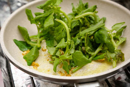 Spinach salad in the pan with oil smothered.