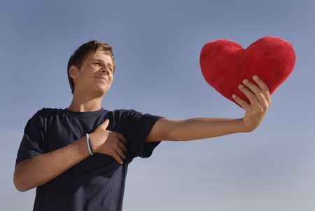 Boy in love holding a big red heart