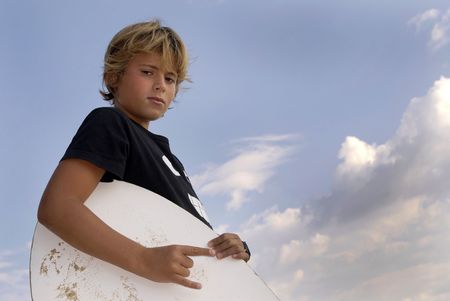 Boy posing in the beach with a skim-boardの写真素材