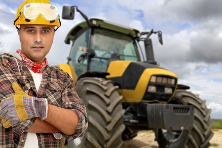Worker with tractor on the backgroundの写真素材